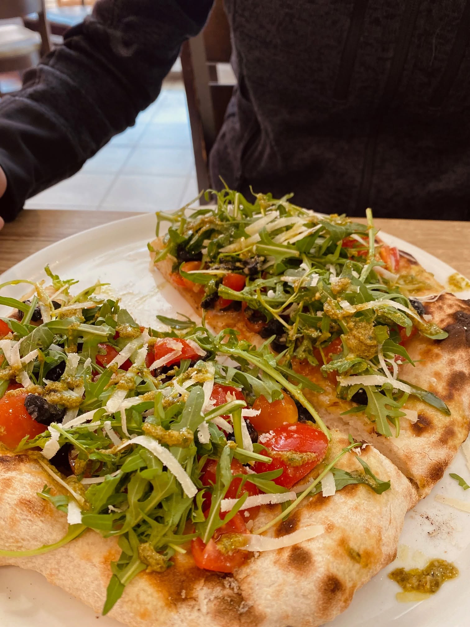 Italienische Pizza mit Rucola und Tomaten bei Pulcinella